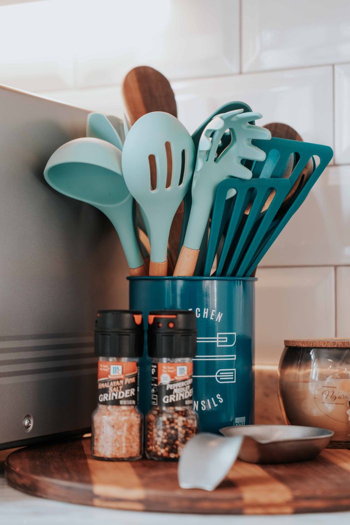 Aesthetic kitchen utensils and spices setup on a wooden board for modern decor.