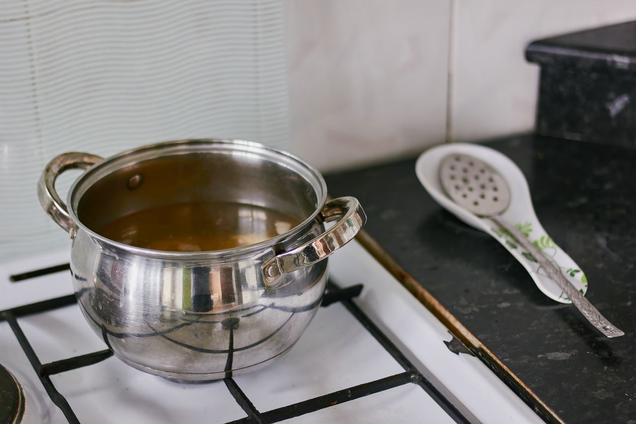 A stainless steel pot on a stove in a contemporary kitchen setting.